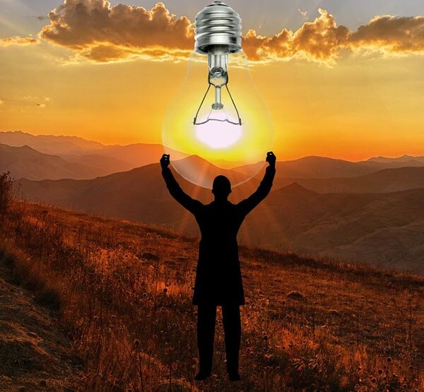 Man with arms stretched to sky looks like holding giant solar lightbulb