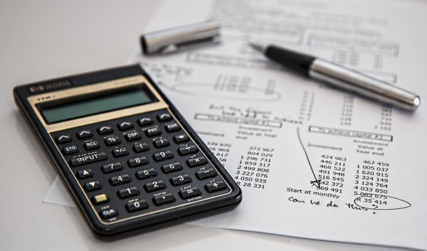Calculator and paper with numbers sitting on desk respresenting business term loans.