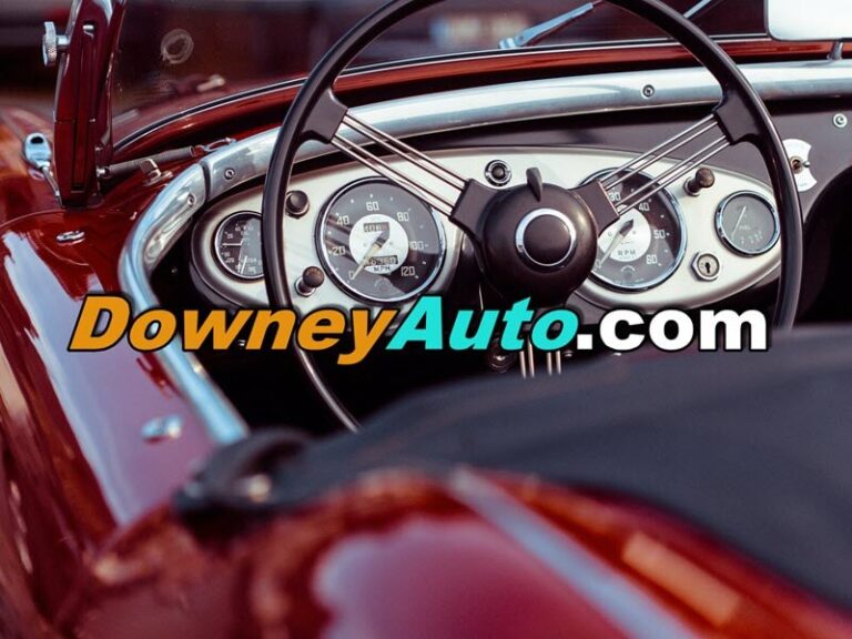 Picture of the interior of an older car showing steering wheel and odometer for Downey Auto.